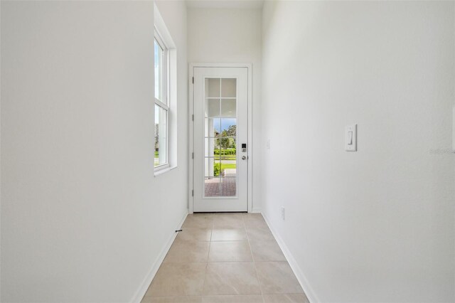 doorway to outside with light tile patterned floors