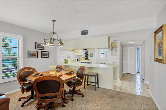 dining space with a chandelier, light colored carpet, and a textured ceiling