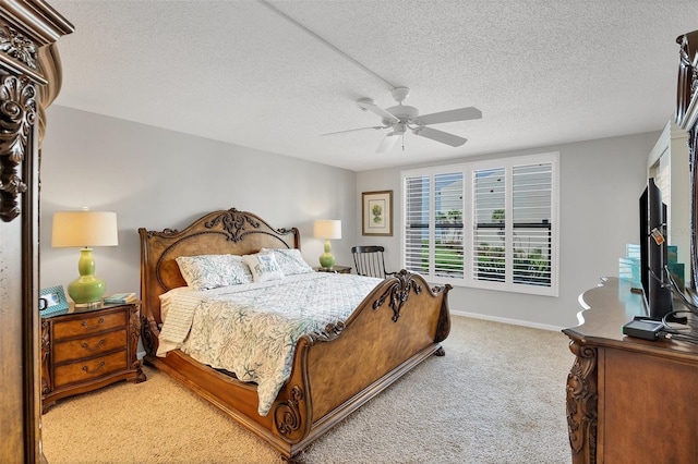 carpeted bedroom featuring ceiling fan and a textured ceiling