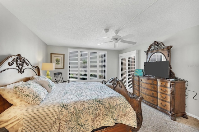 carpeted bedroom featuring ceiling fan and a textured ceiling