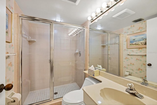 bathroom with toilet, an enclosed shower, and vanity