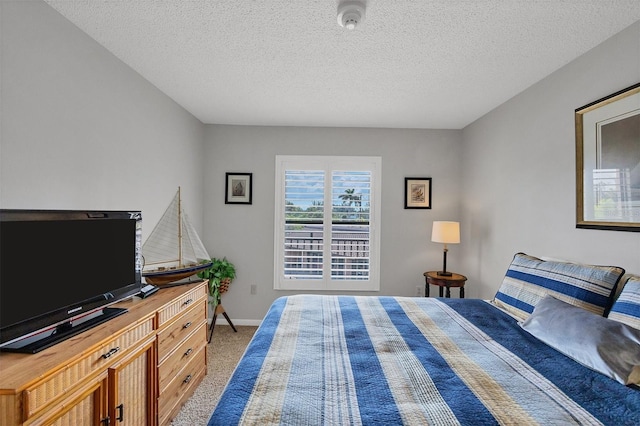 bedroom with a textured ceiling and light colored carpet