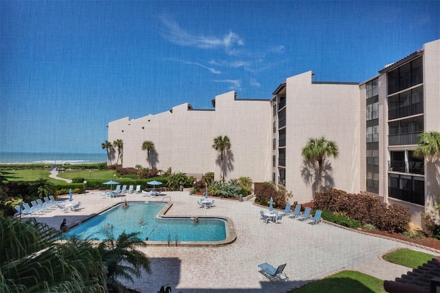 view of pool with a patio area and a water view