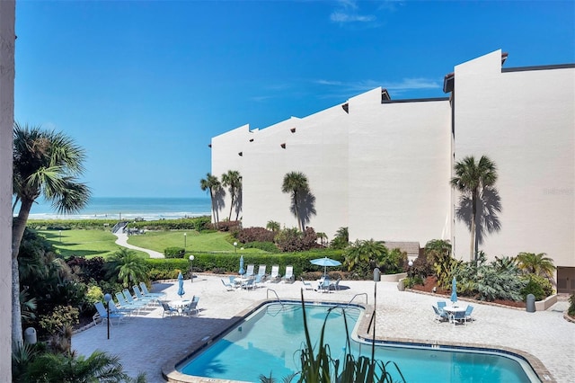 view of pool featuring a patio area and a water view