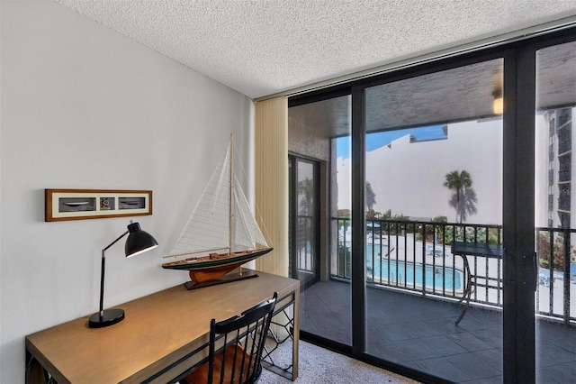 doorway to outside featuring expansive windows and a textured ceiling