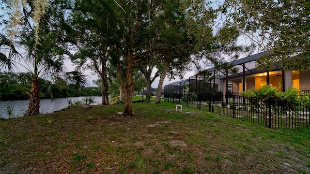 view of yard featuring a water view and glass enclosure