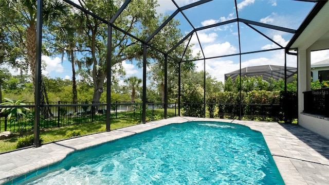 view of swimming pool featuring a patio area and a lanai