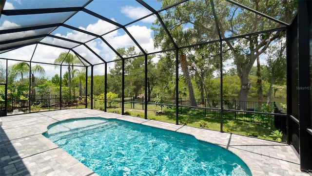 view of swimming pool featuring a patio area and a lanai