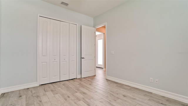 unfurnished bedroom featuring light hardwood / wood-style floors and a closet