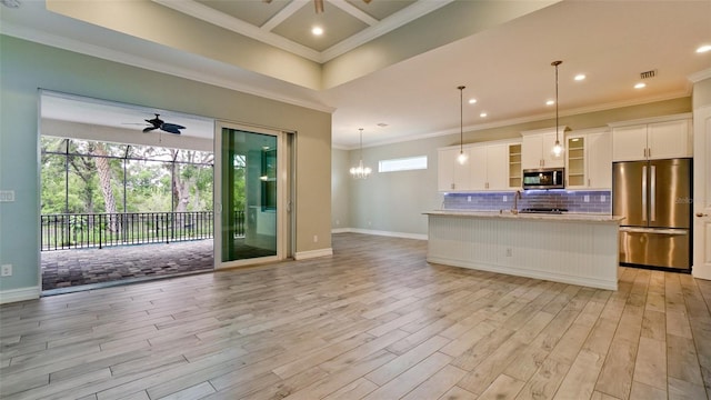 kitchen featuring appliances with stainless steel finishes, light wood-type flooring, ceiling fan with notable chandelier, white cabinetry, and pendant lighting