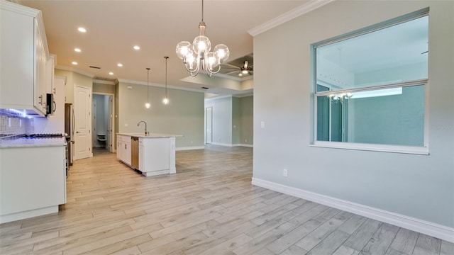 kitchen with an island with sink, white cabinets, light wood-type flooring, and pendant lighting