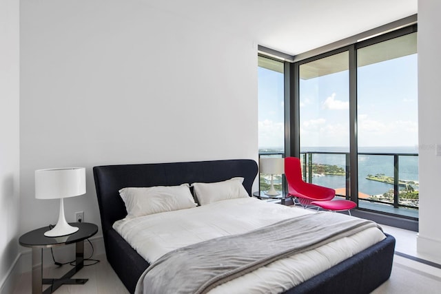 bedroom featuring floor to ceiling windows and a water view