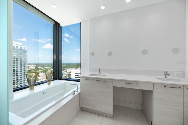 bathroom with a washtub, tile floors, and vanity