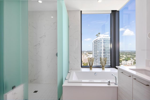 bathroom featuring tile walls, plus walk in shower, and vanity