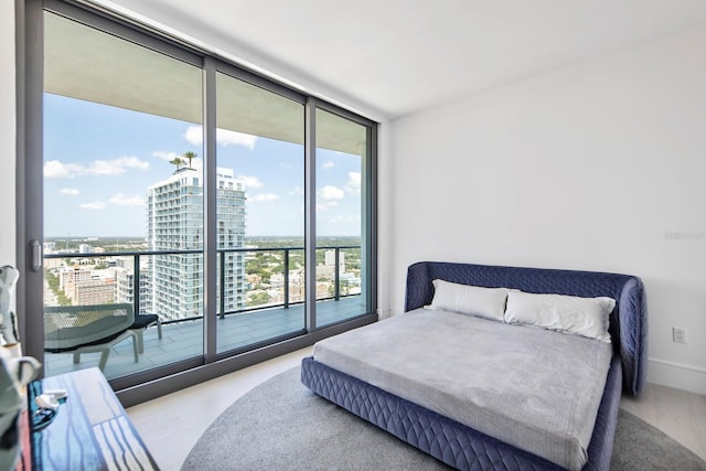 bedroom with light hardwood / wood-style flooring, a wall of windows, access to outside, and multiple windows