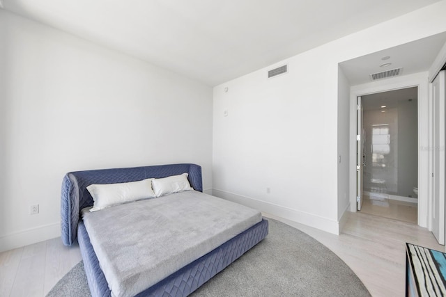 bedroom featuring light hardwood / wood-style floors and connected bathroom