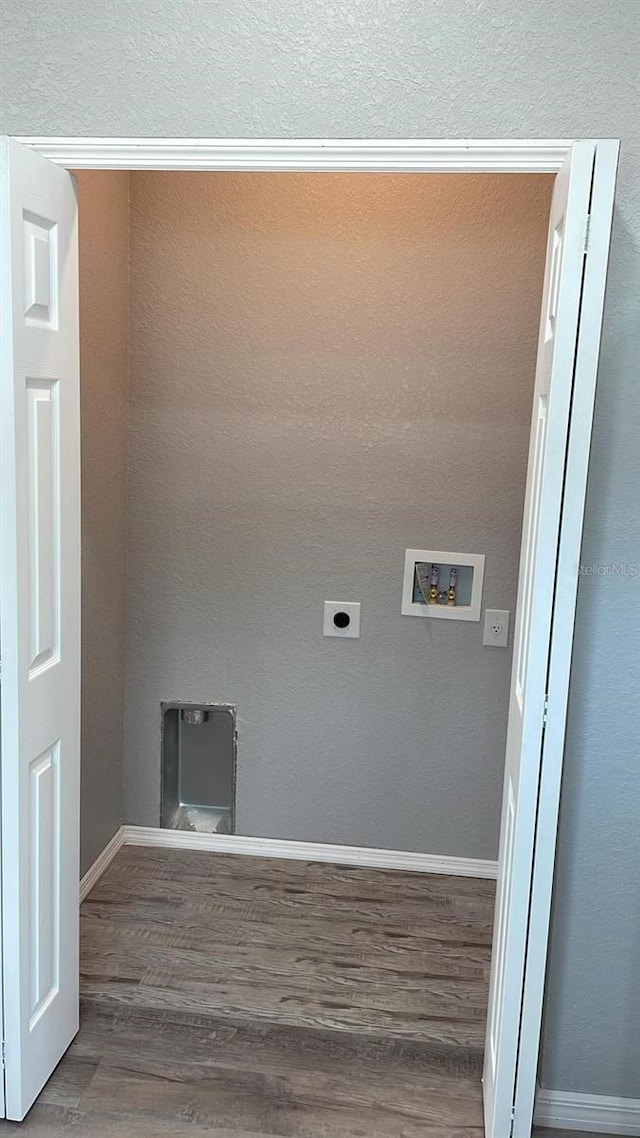 clothes washing area with washer hookup, wood-type flooring, electric dryer hookup, and a textured ceiling