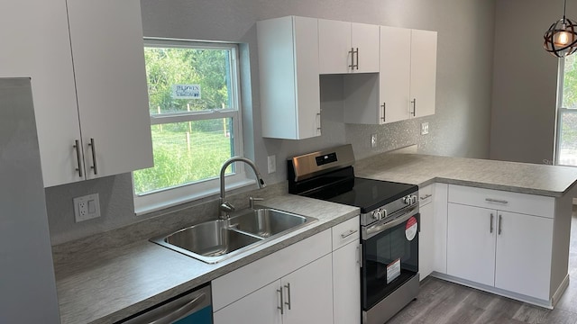 kitchen with white cabinetry, appliances with stainless steel finishes, decorative light fixtures, and sink