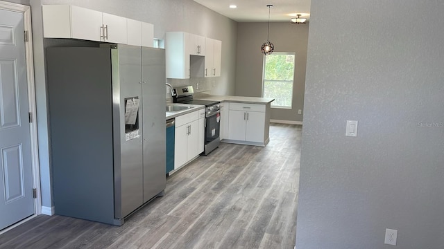 kitchen featuring pendant lighting, appliances with stainless steel finishes, white cabinets, and light hardwood / wood-style floors