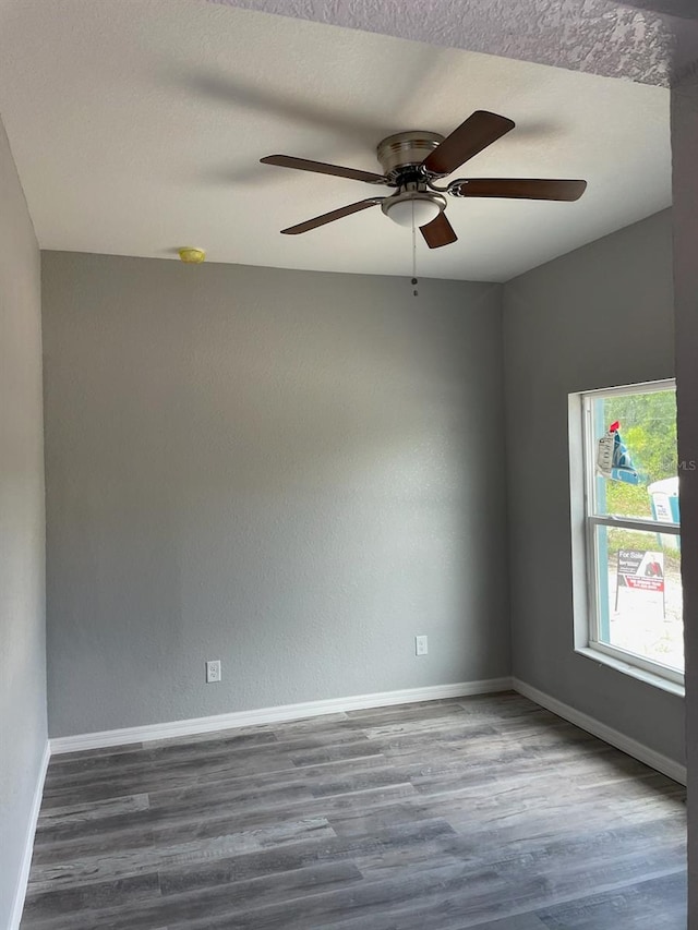 unfurnished room featuring a textured ceiling, dark wood-type flooring, and ceiling fan