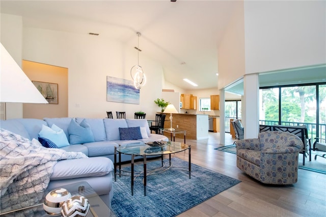 living room featuring wood-type flooring and high vaulted ceiling