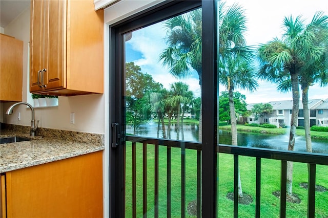 doorway to outside featuring sink and a water view