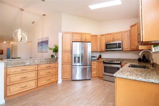 kitchen with appliances with stainless steel finishes, light stone countertops, light wood-type flooring, decorative light fixtures, and sink