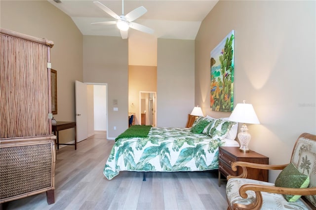 bedroom featuring high vaulted ceiling, ensuite bath, wood finished floors, and a ceiling fan