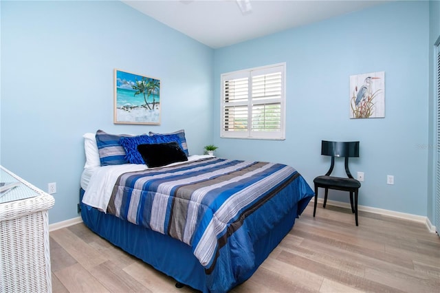 bedroom featuring light wood-style flooring and baseboards