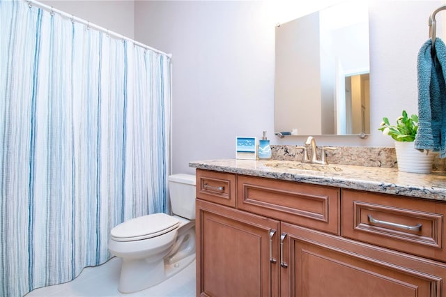 bathroom featuring tile patterned flooring, a shower with curtain, vanity, and toilet