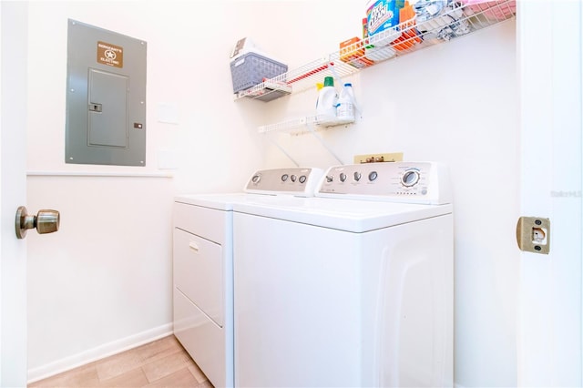 clothes washing area with washer and clothes dryer and electric panel