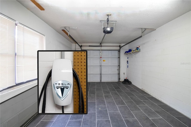 garage featuring concrete block wall and a garage door opener