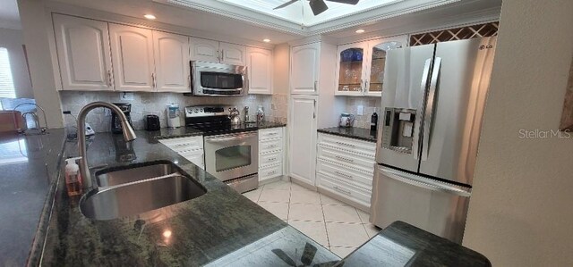 kitchen featuring white cabinetry, stainless steel appliances, sink, tasteful backsplash, and ceiling fan