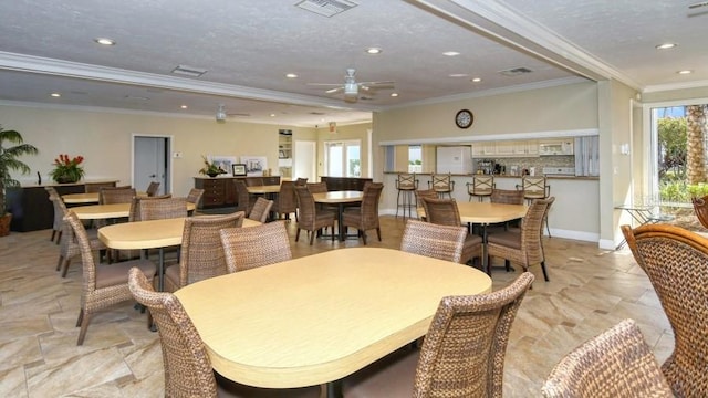 tiled dining area with ceiling fan, a textured ceiling, and crown molding