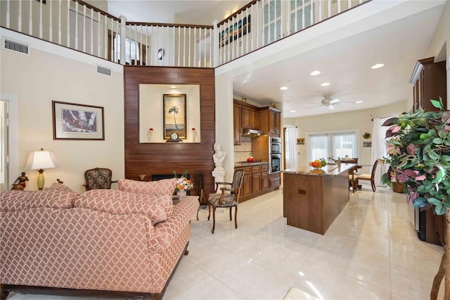 tiled living room featuring a high ceiling and ceiling fan