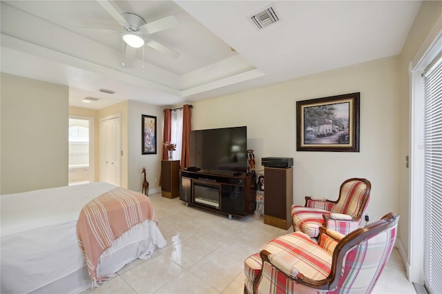 tiled bedroom featuring connected bathroom, a closet, ceiling fan, and a tray ceiling