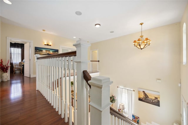 hallway with a chandelier and dark hardwood / wood-style floors