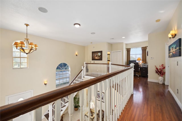 hall featuring dark hardwood / wood-style floors and a chandelier