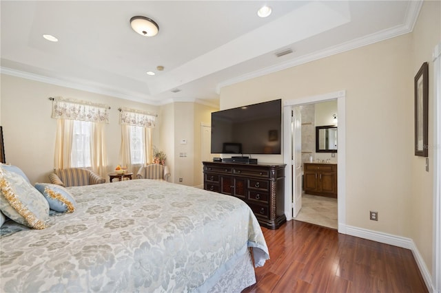 bedroom with connected bathroom, crown molding, a raised ceiling, and dark hardwood / wood-style flooring