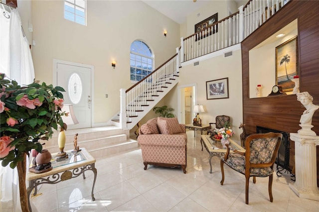 entryway featuring a towering ceiling, light tile floors, and a wealth of natural light