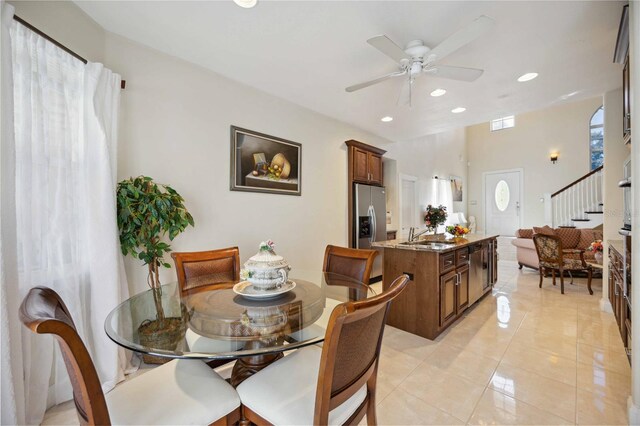 dining area with ceiling fan, light tile floors, and sink