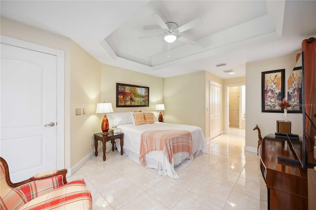 bedroom with light tile floors, a raised ceiling, and ceiling fan