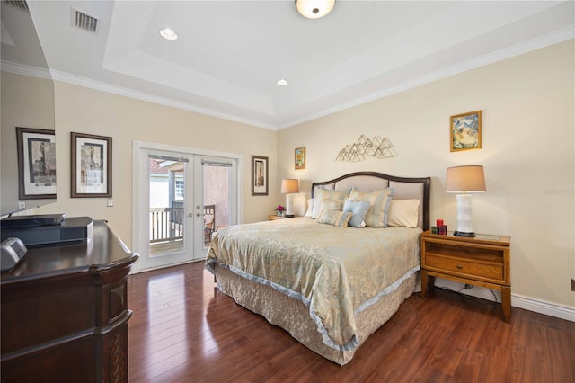 bedroom featuring french doors, access to exterior, a tray ceiling, and dark wood-type flooring