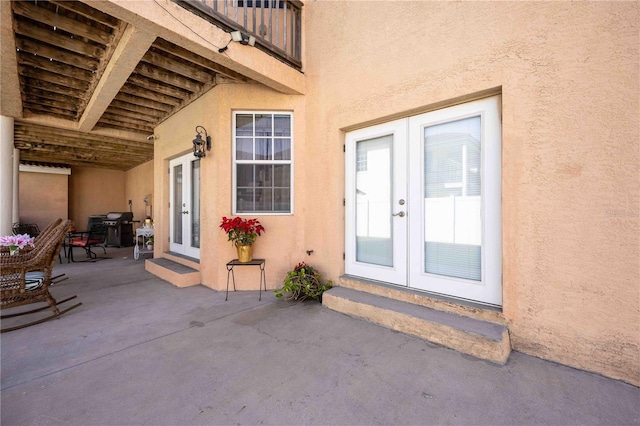 view of exterior entry with a patio area and french doors