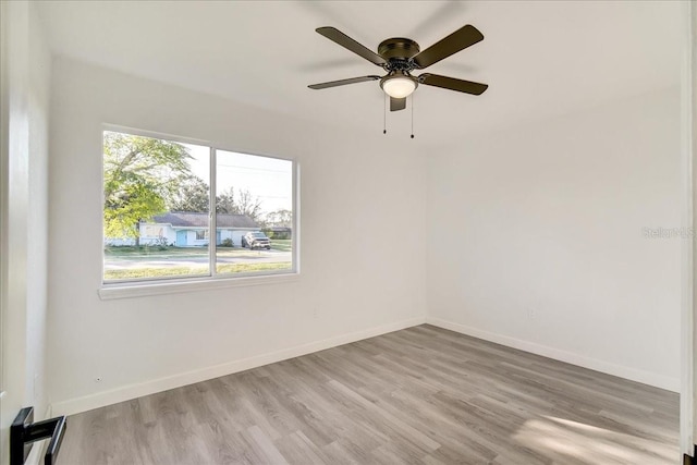 unfurnished room featuring a healthy amount of sunlight, ceiling fan, and light hardwood / wood-style flooring