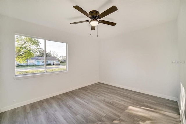 empty room featuring hardwood / wood-style floors, ceiling fan, and a wealth of natural light