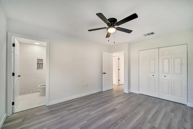 unfurnished bedroom with ensuite bath, ceiling fan, a closet, and light hardwood / wood-style flooring