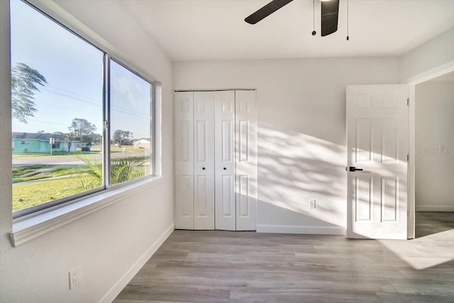 unfurnished bedroom featuring a closet, ceiling fan, and hardwood / wood-style flooring