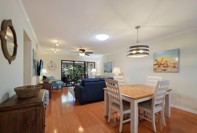 dining room featuring crown molding, light hardwood / wood-style floors, and ceiling fan with notable chandelier