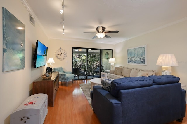 living room with ornamental molding, light hardwood / wood-style floors, ceiling fan, and rail lighting